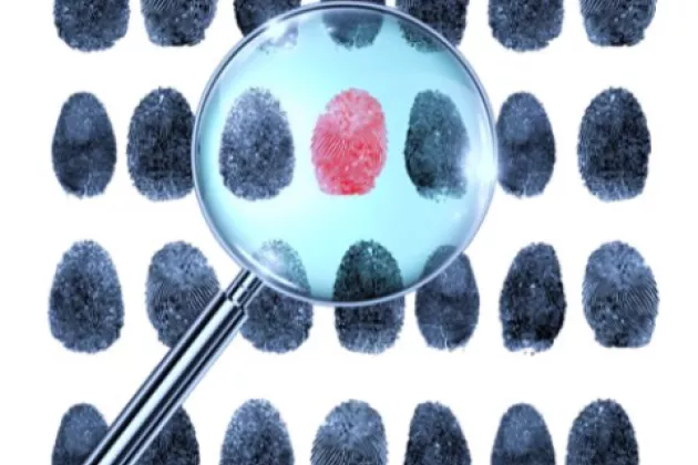 Image of fingerprints scrutinied through magnifying glass